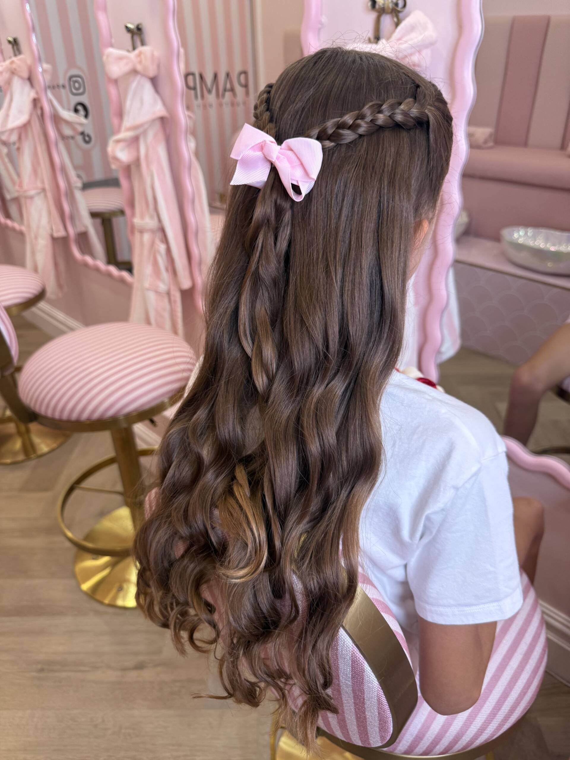 A guest with styled curls and a pink bow