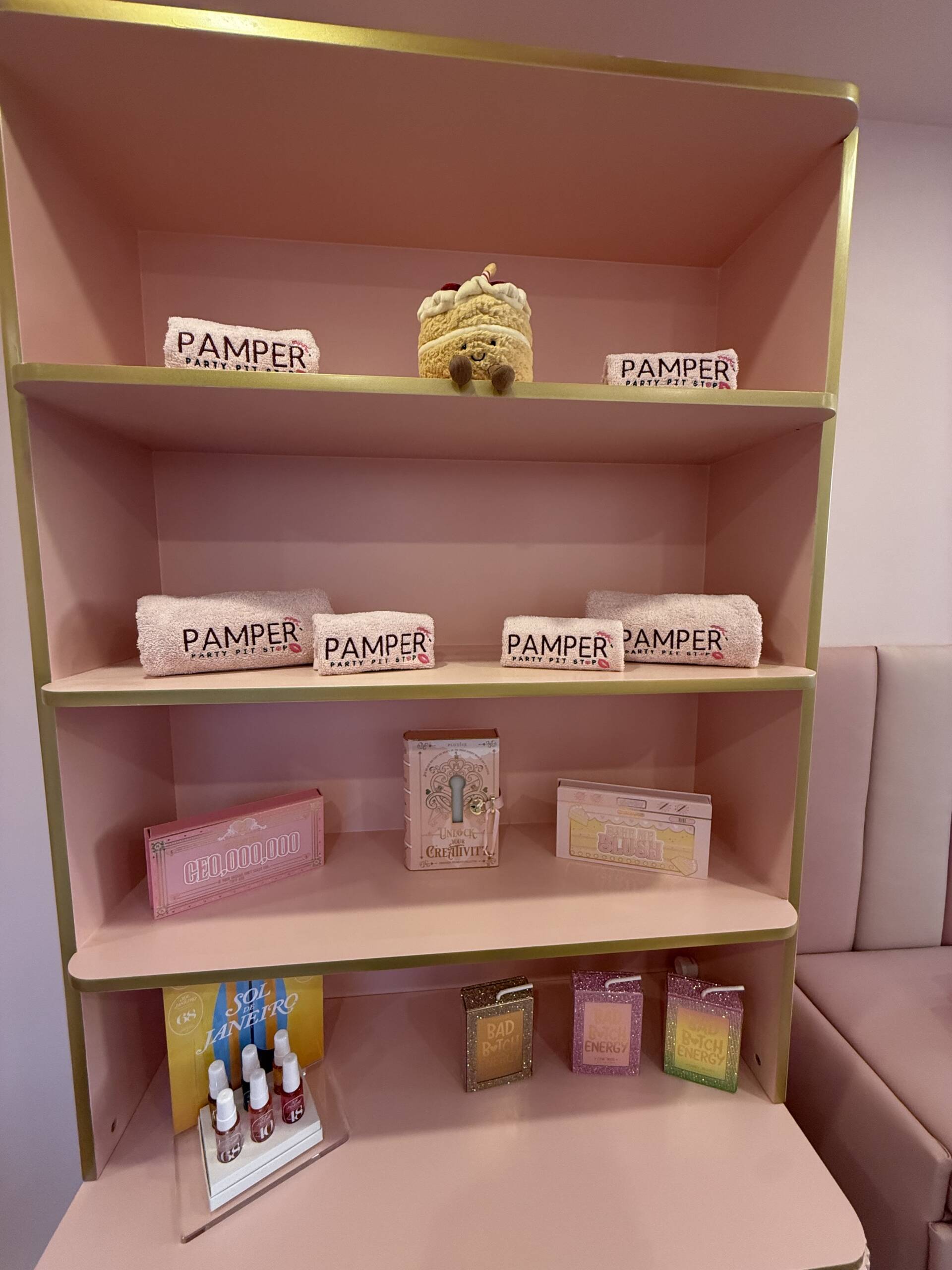 Pamper products and supplies on pink shelves