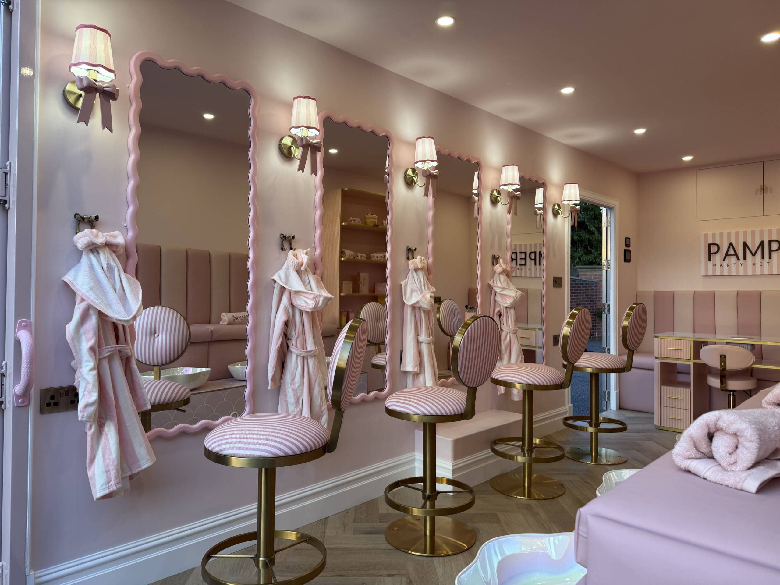 Pink salon chairs and mirrors inside the pamper van