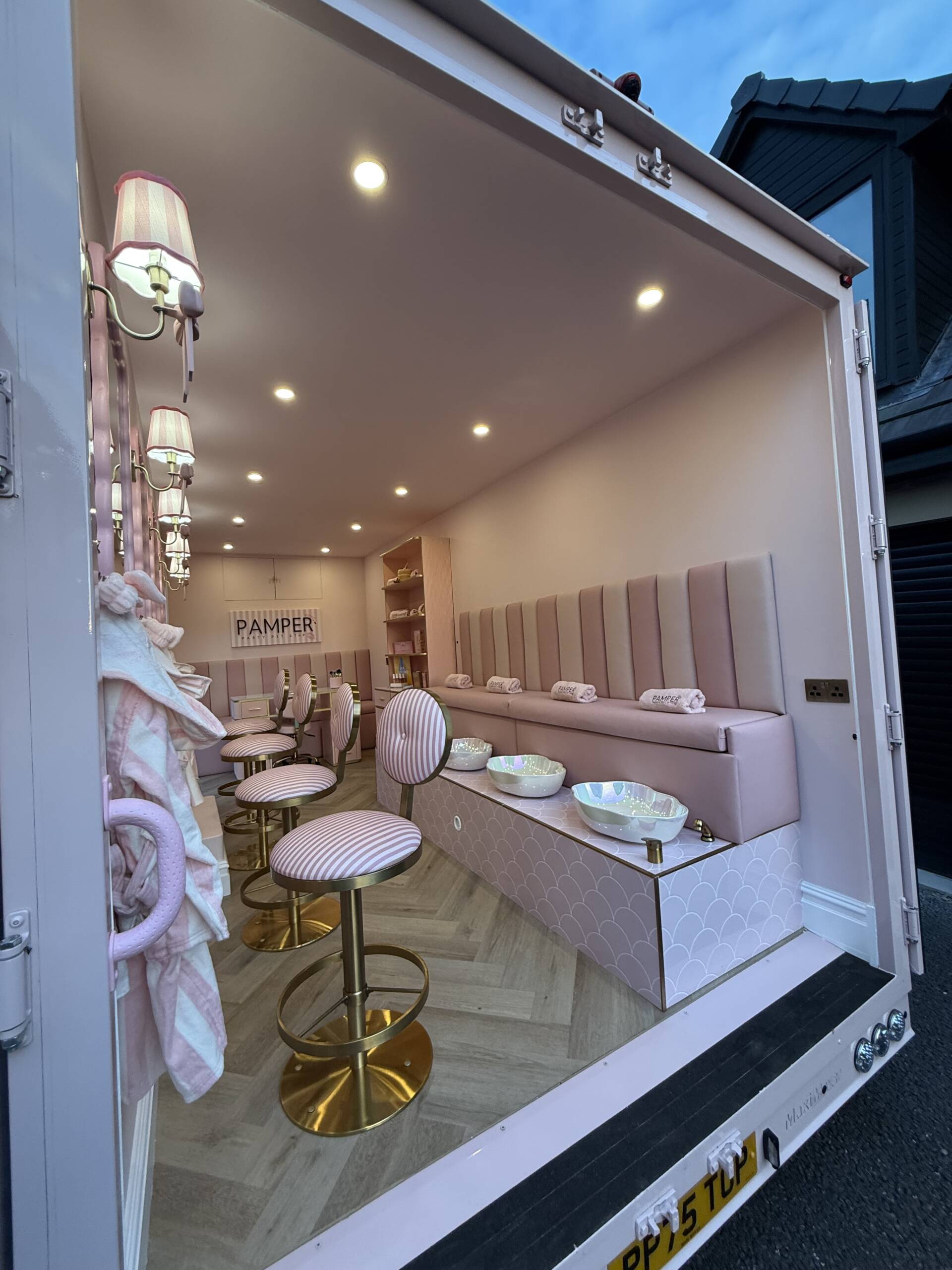 Pink seating and styling stations inside the van